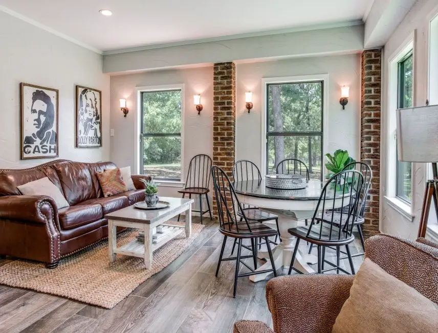 A modern contemporary breakfast area with windows, a small table and couch.