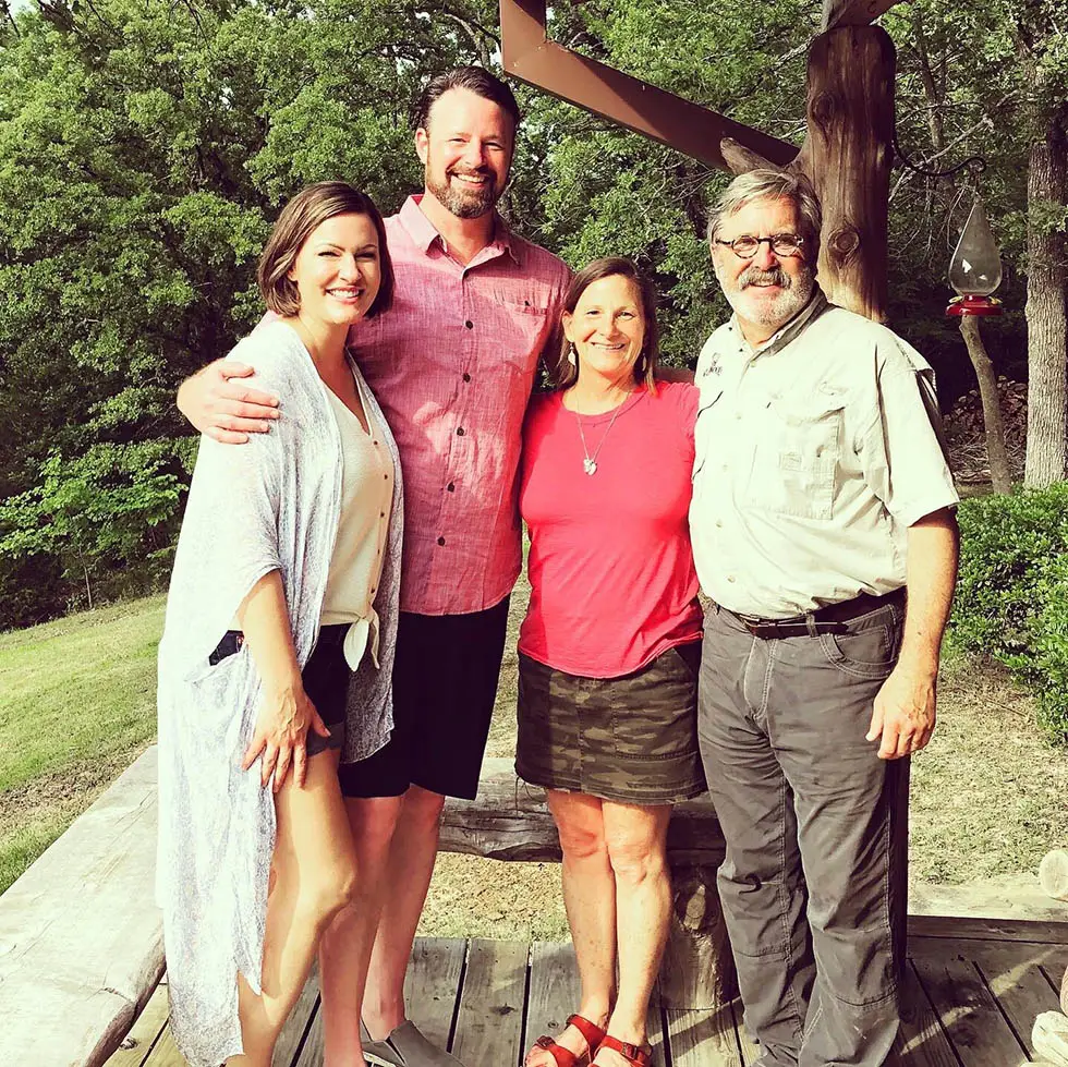 The previous owners The Johnsons and the new owners The Jones happily standing outside arm in arm.